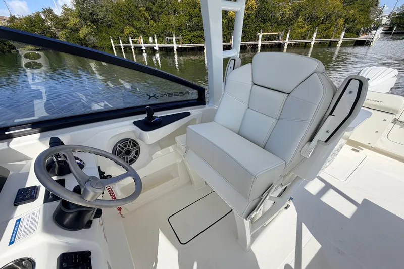 Slide: The Image of 2026 World Cat 265 DC-X boat interior with steering wheel and white seating. - 10