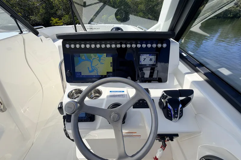 Slide: The Image of 2026 World Cat 265 DC-X boat dashboard with navigation screen and steering wheel. - 12