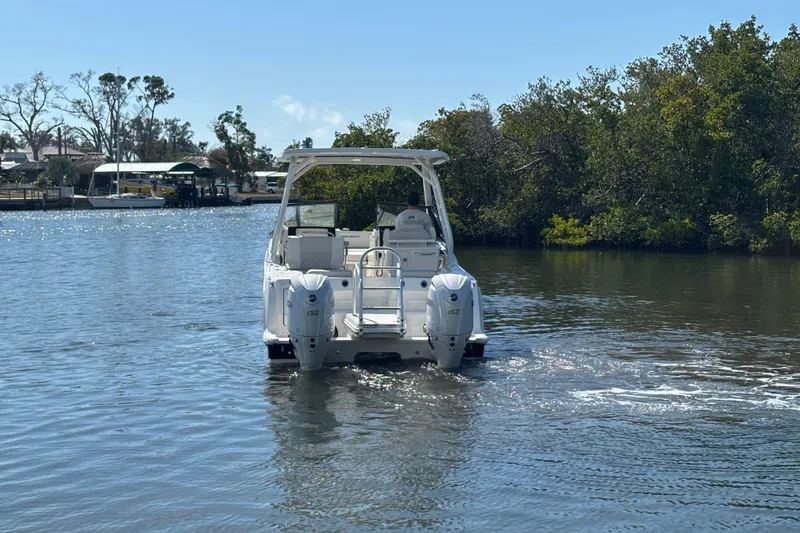 Slide: The Image of 2026 World Cat 265 DC-X boat cruising on a calm river with lush greenery. - 5