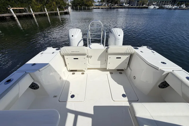 Slide: The Image of 2026 World Cat 265 DC-X boat interior with dual engines, docked on calm water. - 6