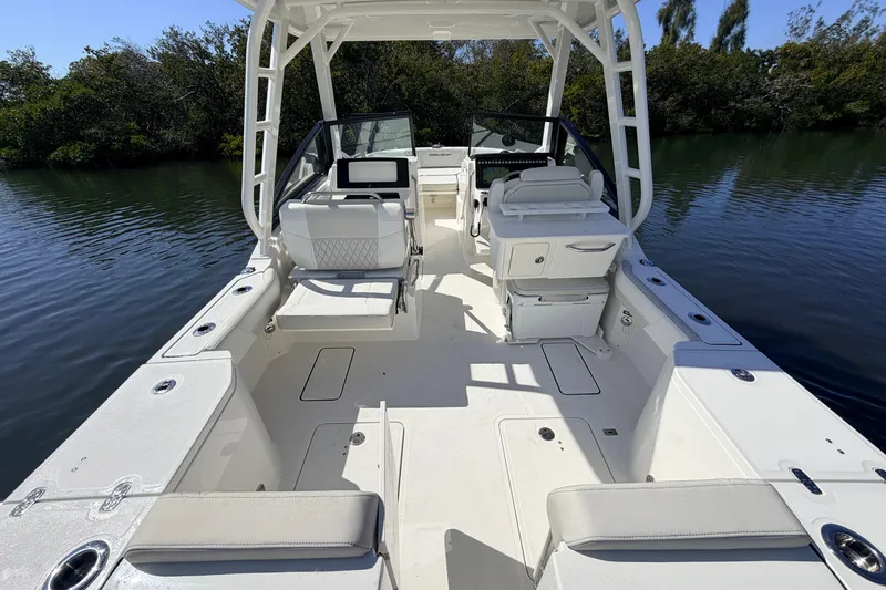 Slide: The Image of 2026 World Cat 265 DC-X boat interior with seating and helm, on calm water. - 9