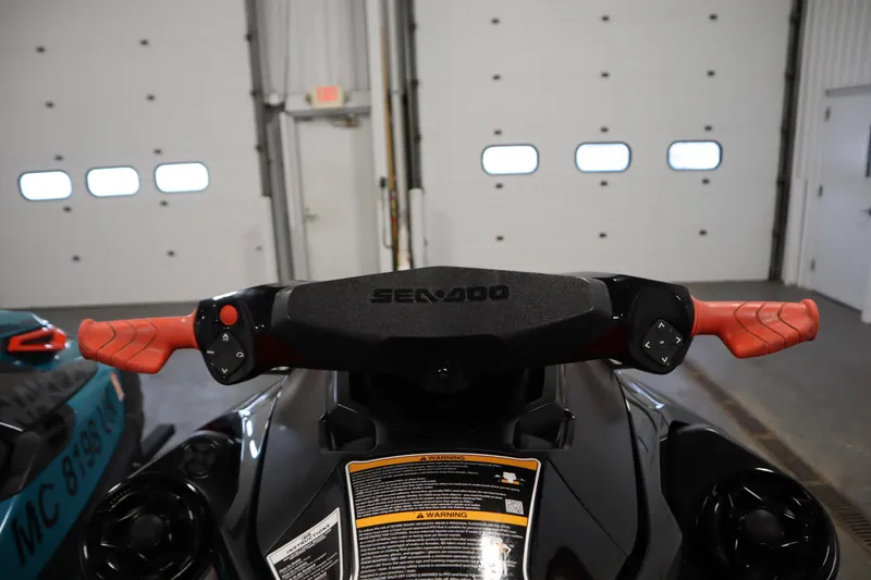Slide: The Image of 2019 Sea-Doo Wake Pro 230 handlebars with red grips in a garage setting. - 22