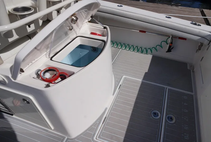 Slide: The Image of Jupiter 30 FS 2015 boat deck with open storage compartment and coiled hose. - 13
