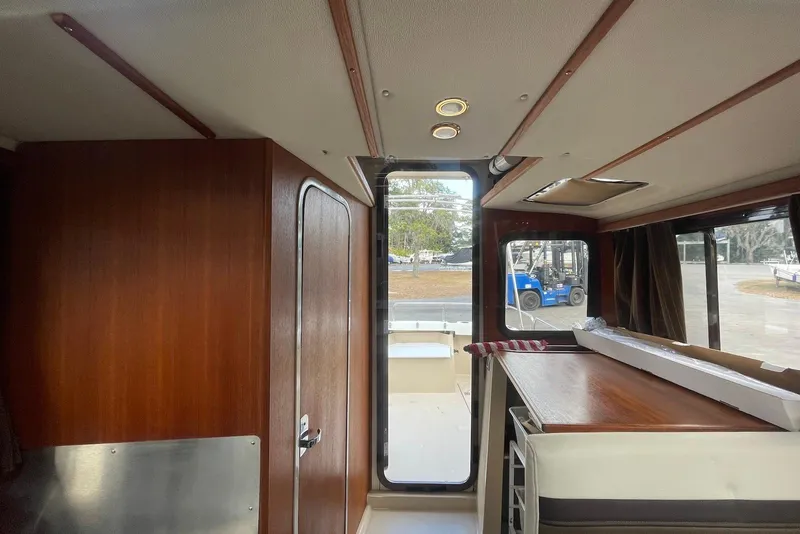 Slide: The Image of Interior of 2012 Ranger Tugs R-27 boat with wood paneling and outdoor view. - 10