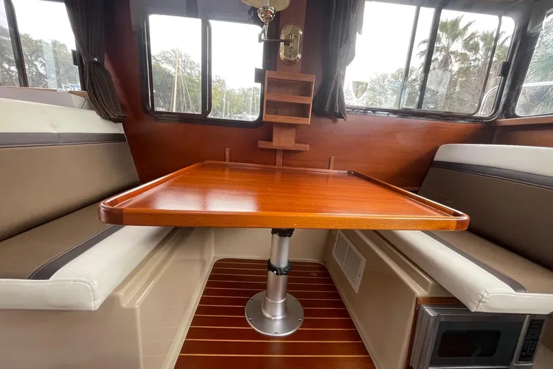 Slide: The Image of Interior of 2012 Ranger Tugs R-27 with wooden table and cushioned seating. - 15