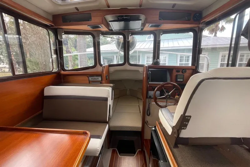 Slide: The Image of Interior of 2012 Ranger Tugs R-27 boat with wood accents and seating. - 16