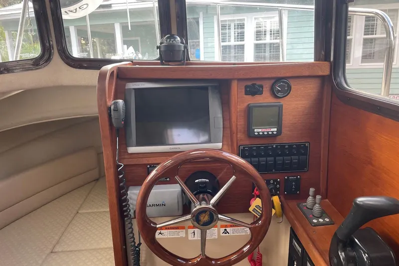 Slide: The Image of 2012 Ranger Tugs R-27 helm with Garmin navigation and wood finish. - 17