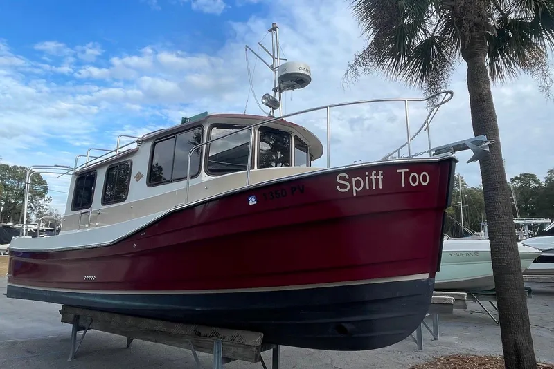 Slide: The Image of 2012 Ranger Tugs R-27 boat named "Spiff Too" on dry dock under a blue sky. - 4