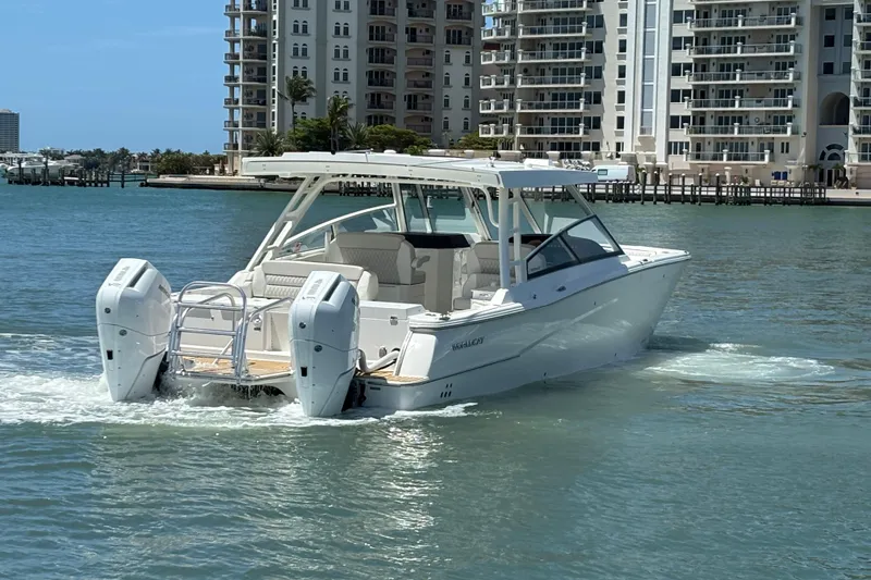 Slide: The Image of 2026 World Cat 400 DC-X Island boat cruising near waterfront buildings. - 11