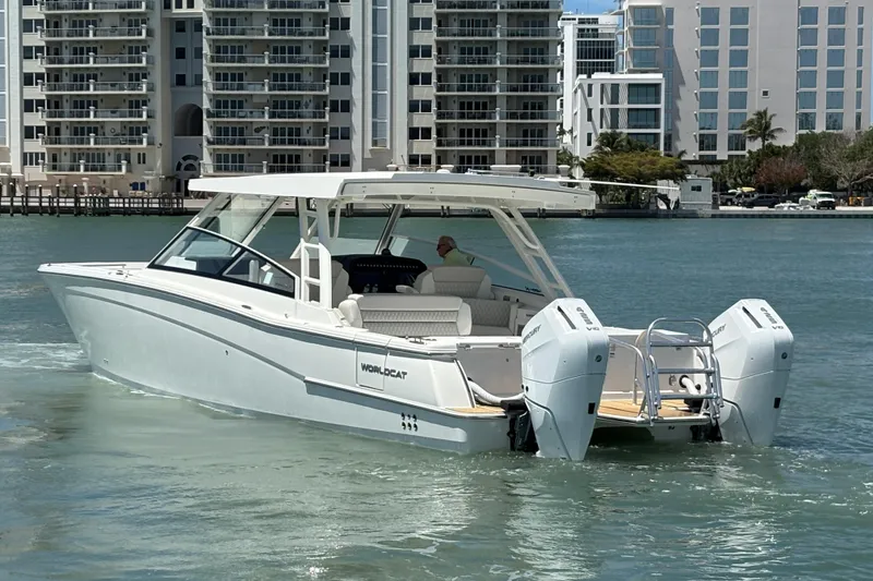 Slide: The Image of 2026 World Cat 400 DC-X Island boat cruising near modern waterfront buildings. - 12