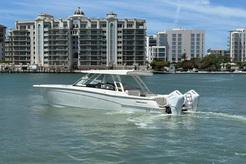 Slide: The Image of 2026 World Cat 400 DC-X Island boat cruising near waterfront buildings. - 13