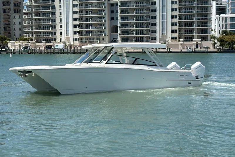 Slide: The Image of 2026 World Cat 400 DC-X Island boat cruising near waterfront buildings. - 14