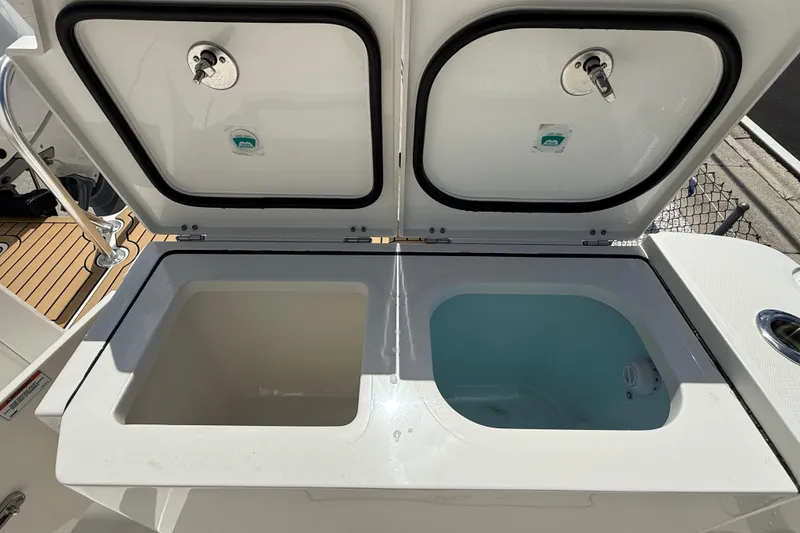 Slide: The Image of Livewell compartments on 2026 World Cat 400 DC-X Island boat, open lids showing interior. - 22