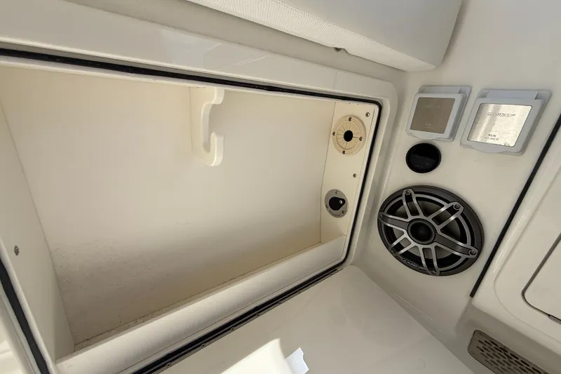 Slide: The Image of Interior view of 2026 World Cat 400 DC-X Island boat, featuring storage compartment and speaker system. - 27