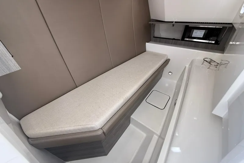 Slide: The Image of Interior of 2026 World Cat 400 DC-X Island boat, featuring a cushioned bench and modern amenities. - 33