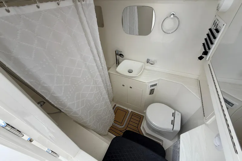 Slide: The Image of Bathroom interior of 2026 World Cat 400 DC-X Island boat, featuring shower, sink, and toilet. - 39