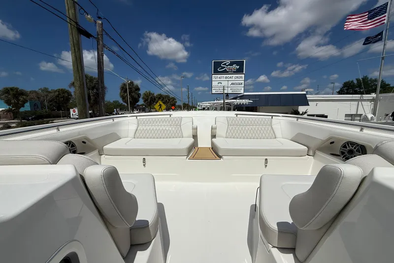 Slide: The Image of 2026 World Cat 400 DC-X Island boat with luxurious seating, displayed outdoors under a clear sky. - 42