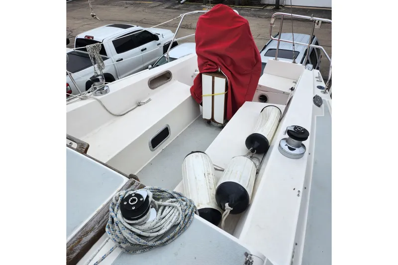 The Image of 1992 Catalina 36 sailboat deck with ropes, fenders, and covered equipment. - 1