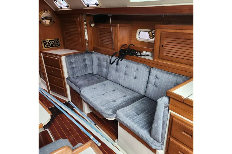 Slide: The Image of Interior of 1992 Catalina 36 sailboat with wooden cabinetry and blue cushioned seating. - 10