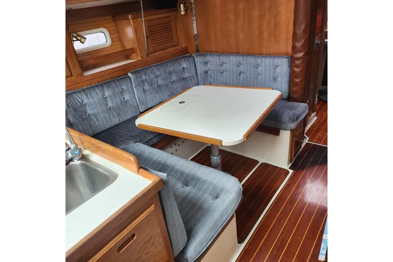 Slide: The Image of Interior of 1992 Catalina 36 sailboat with cozy dining area and wooden flooring. - 11