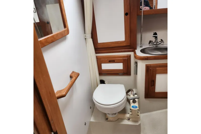 Slide: The Image of 1992 Catalina 36 yacht bathroom with wooden accents, toilet, and sink. - 14
