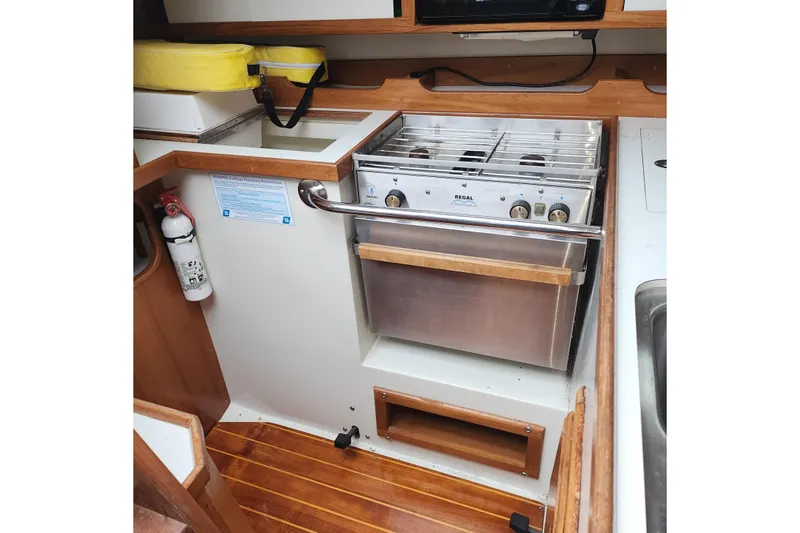 Slide: The Image of Galley kitchen in 1992 Catalina 36 sailboat with stove and wooden accents. - 16