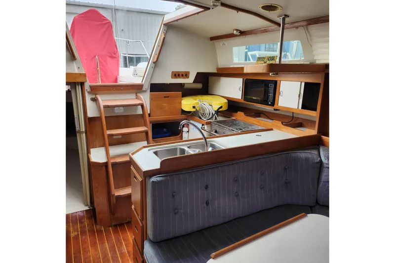 Slide: The Image of Interior of 1992 Catalina 36 sailboat with kitchen, seating, and wooden accents. - 7