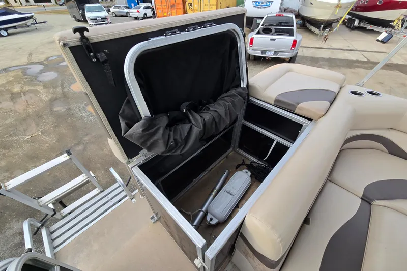 Slide: The Image of 2012 Berkshire 230 CL LSR boat storage compartment with open lid and visible equipment. - 11
