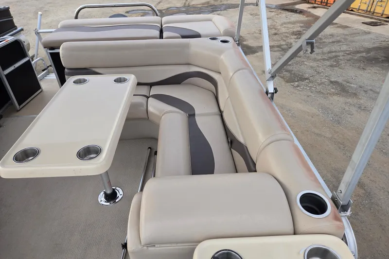 Slide: The Image of 2012 Berkshire 230 CL LSR pontoon boat interior with beige seating and table. - 15