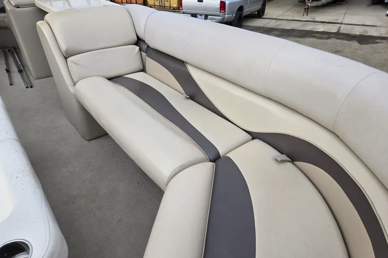 Slide: The Image of 2012 Berkshire 230 CL LSR boat interior with beige and gray seating. - 16