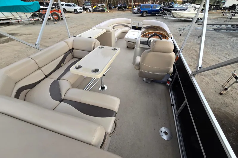 Slide: The Image of 2012 Berkshire 230 CL LSR pontoon boat interior with beige seating and table. - 17