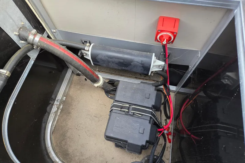 Slide: The Image of 2012 Berkshire 230 CL LSR boat battery compartment with wiring and switch. - 26