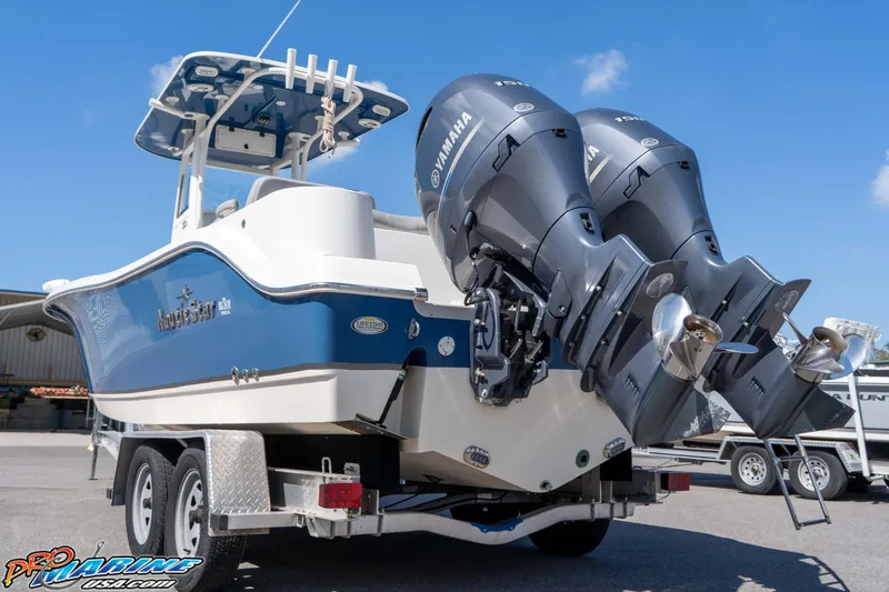 Slide: The Image of 2021 NauticStar 2602 Legacy boat with dual Yamaha engines on a trailer. - 11