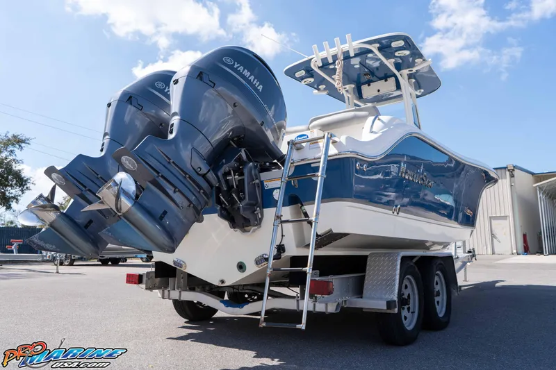 Slide: The Image of 2021 NauticStar 2602 Legacy boat with dual Yamaha engines on a trailer. - 14