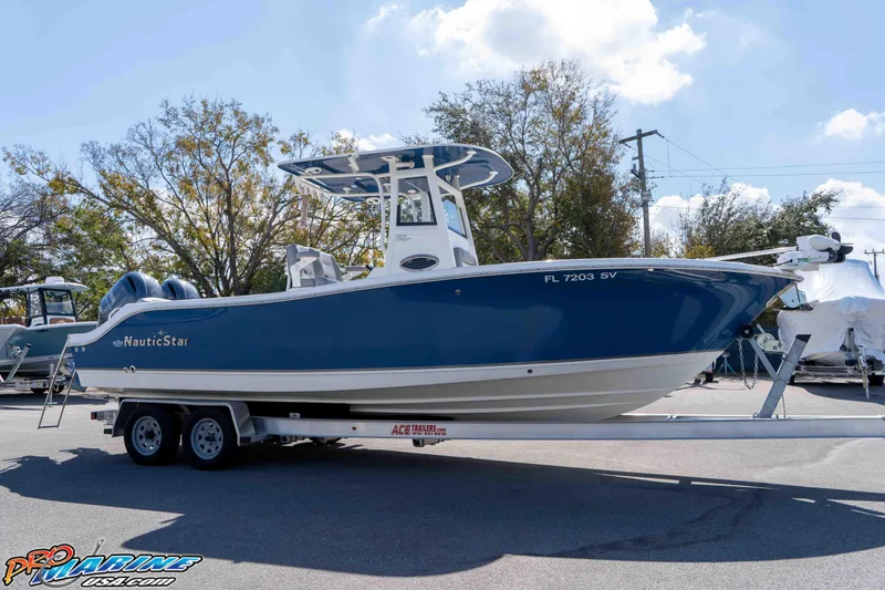 Slide: The Image of 2021 NauticStar 2602 Legacy boat on trailer, blue hull, parked outdoors. - 15