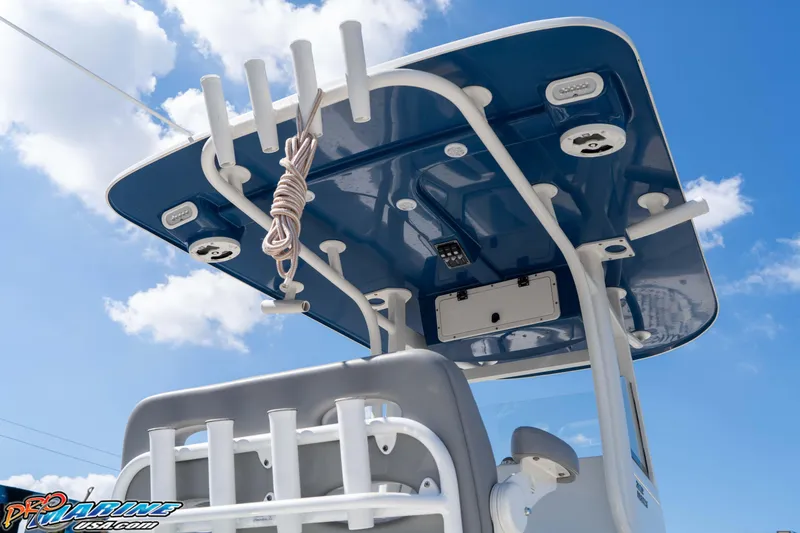 Slide: The Image of 2021 NauticStar 2602 Legacy boat with blue T-top against a bright sky. - 17