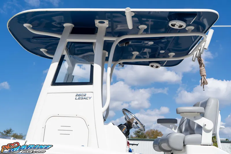 Slide: The Image of 2021 NauticStar 2602 Legacy boat helm with T-top under blue sky. - 18