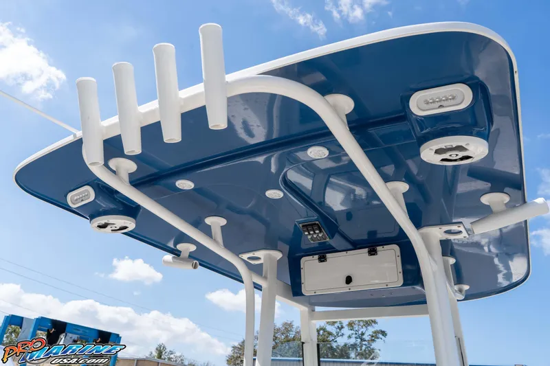 Slide: The Image of 2021 NauticStar 2602 Legacy boat's blue T-top with rod holders and speakers. - 23