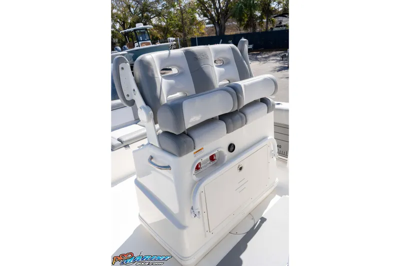 Slide: The Image of 2021 NauticStar 2602 Legacy boat seating with gray cushions and storage compartment. - 26