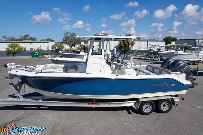 Slide: The Image of 2021 NauticStar 2602 Legacy boat on trailer, blue and white design, outdoor display. - 33