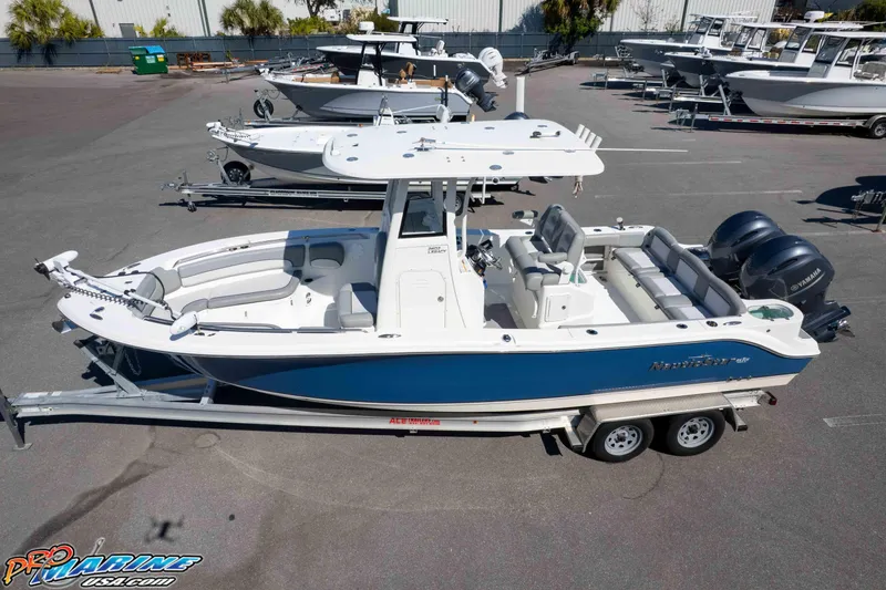 Slide: The Image of 2021 NauticStar 2602 Legacy boat on trailer, featuring dual Yamaha engines. - 34