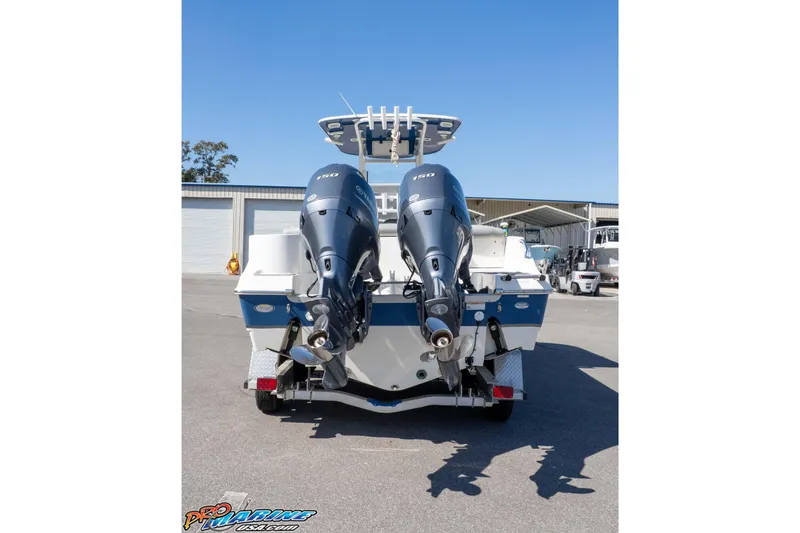 Slide: The Image of 2021 NauticStar 2602 Legacy boat with dual outboard engines, parked outdoors. - 38