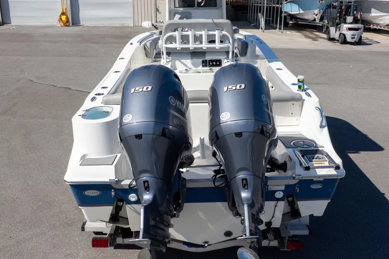 Slide: The Image of 2021 NauticStar 2602 Legacy boat with dual Yamaha 150 engines, docked outdoors. - 39