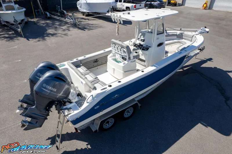 Slide: The Image of 2021 NauticStar 2602 Legacy boat with dual Yamaha engines on trailer. - 43