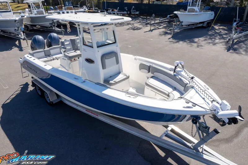Slide: The Image of 2021 NauticStar 2602 Legacy boat on trailer, featuring dual engines and spacious seating. - 49