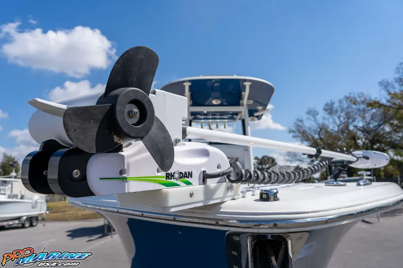 Slide: The Image of 2021 NauticStar 2602 Legacy boat with Rhodan trolling motor, clear sky background. - 5