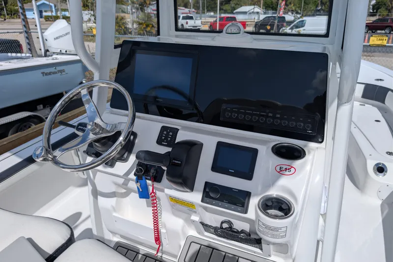 Slide: The Image of 2026 Tidewater 2300 Carolina Bay boat dashboard with steering wheel and electronic controls. - 12