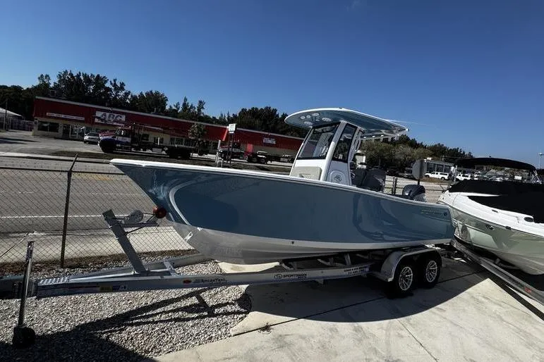 The Image of 2026 Sportsman Open 212 Center Console boat on trailer, parked outdoors. - 0