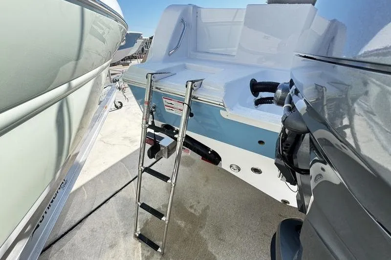 Slide: The Image of 2026 Sportsman Open 212 Center Console boat with ladder and motor, docked outdoors. - 24