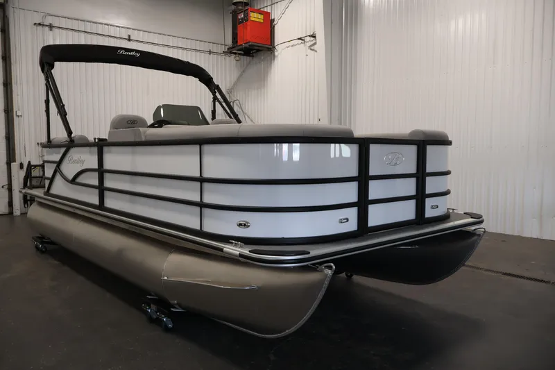 Slide: The Image of 2026 Bentley Pontoons Legacy 200 Navigator in a showroom, showcasing sleek design and modern features. - 2